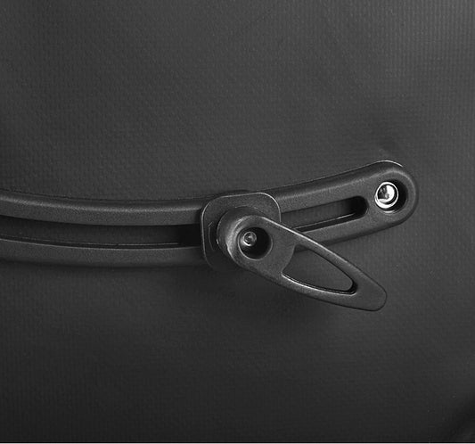 Close-up of a black bicycle pannier attachment on a dark background