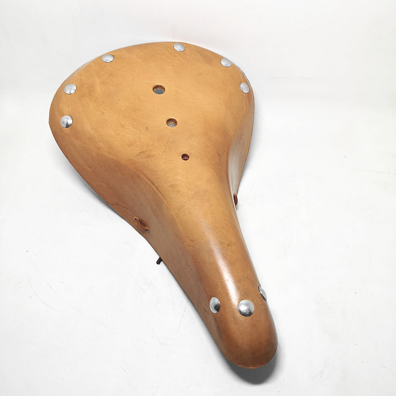 Light brown vintage design leather bicycle seat with silver rivets on a white background
