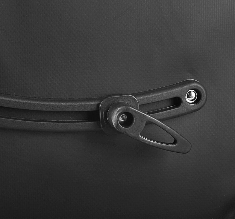 Close-up of a black bicycle pannier attachment on a dark background