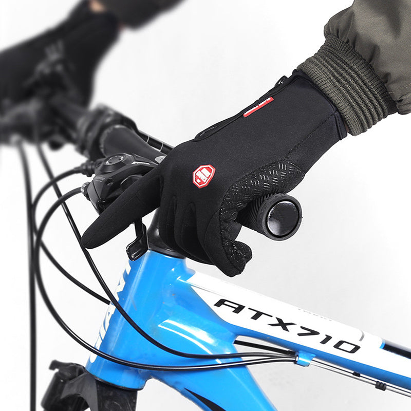 Close-up of a black gloved hand on a bicycle handlebar with a blue bike frame labeled 'ATX710'.