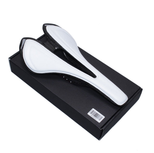 White carbon fibre bicycle saddle on a black box with a white background