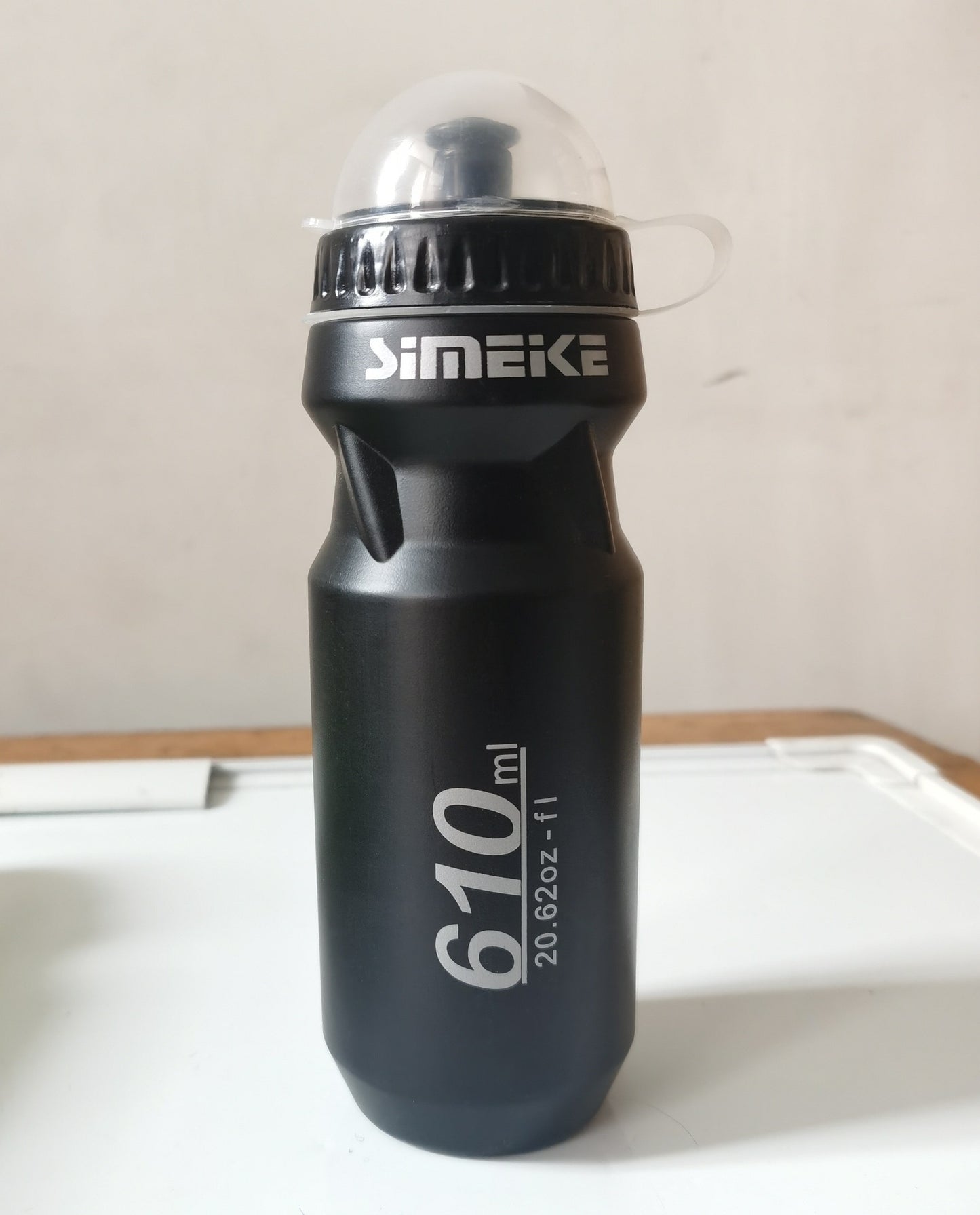 Black cycling water bottle with 'SIMEIKE' branding on a white surface
