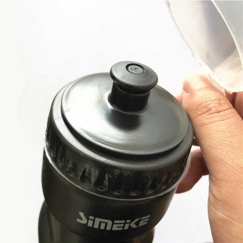Black bicycle water bottle with black cap on a light gray background