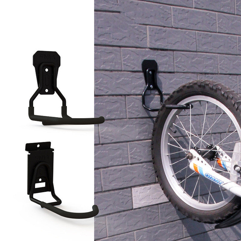 Black bike wheel holder attached to a gray brick wall with a bicycle wheel visible.