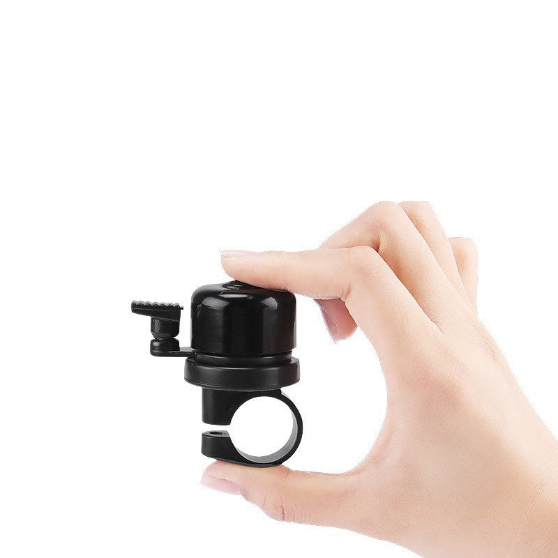 Hand holding a black Anti-theft Bicycle Bell with concealed Airtag Compartment on a white background