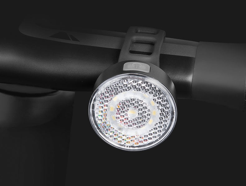 Bicycle light attached to a handlebar on a black background