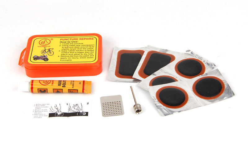 Puncture repair kit with patches, glue, and tools on a white background