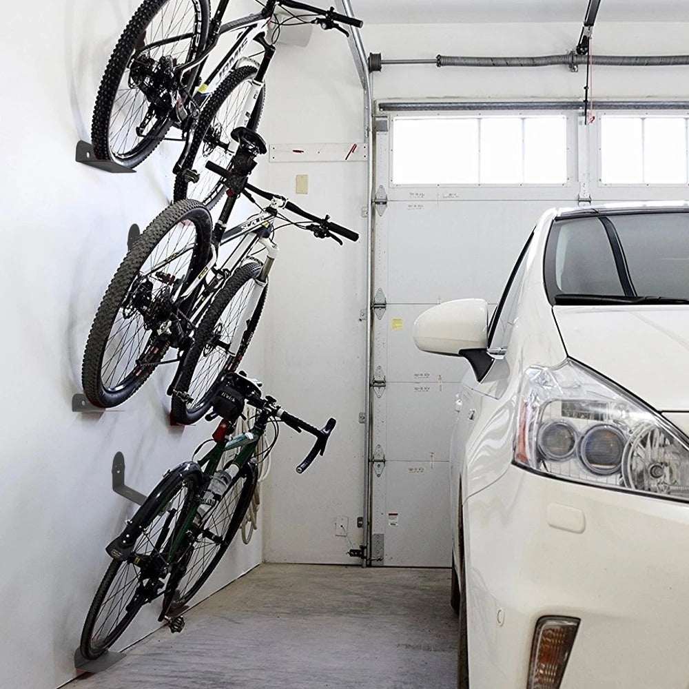 Garage with bicycles hanging on a wall rack and a car parked inside.