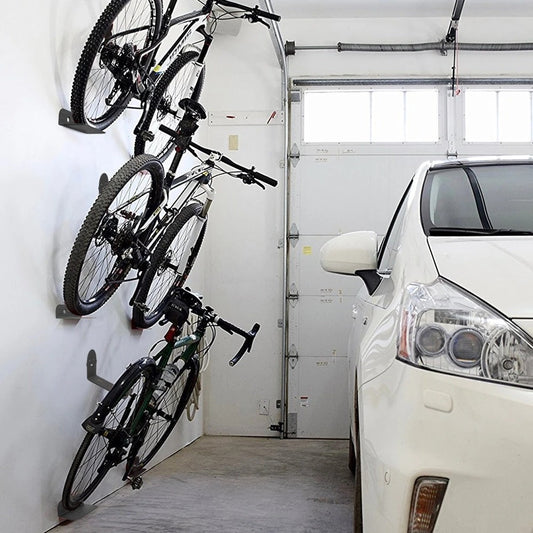 Garage with bicycles hanging on a wall rack and a car parked inside.