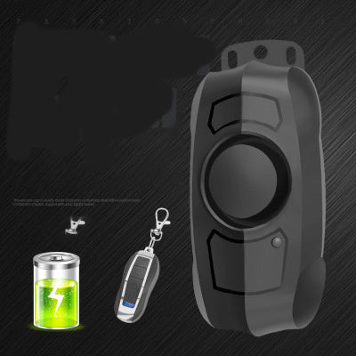 Black electronic bicycle alarm with a remote control and small container on a dark background