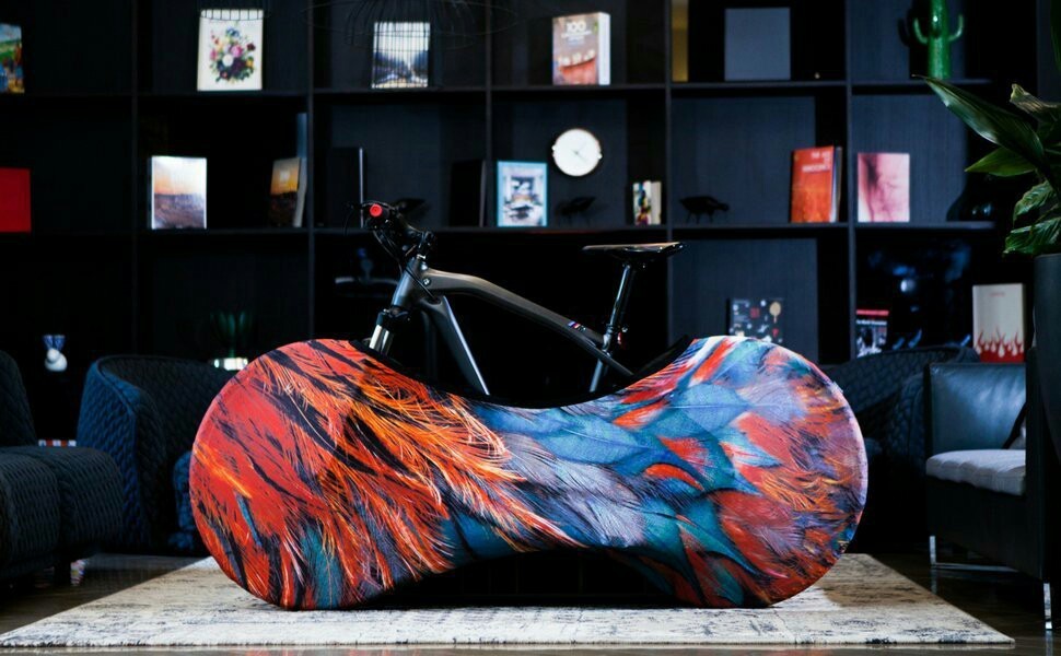 Colorful abstract Dustproof Elasticated Bicycle Cover in a modern interior setting with bookshelves and a bicycle.
