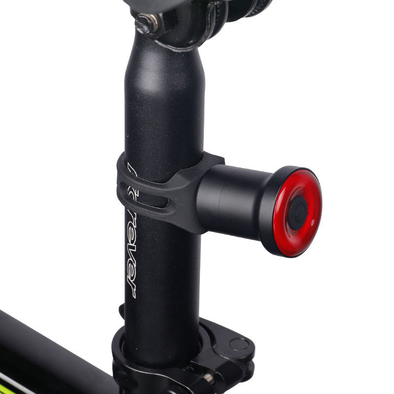 Close-up of a black bike seat post with a red clamp on a white background