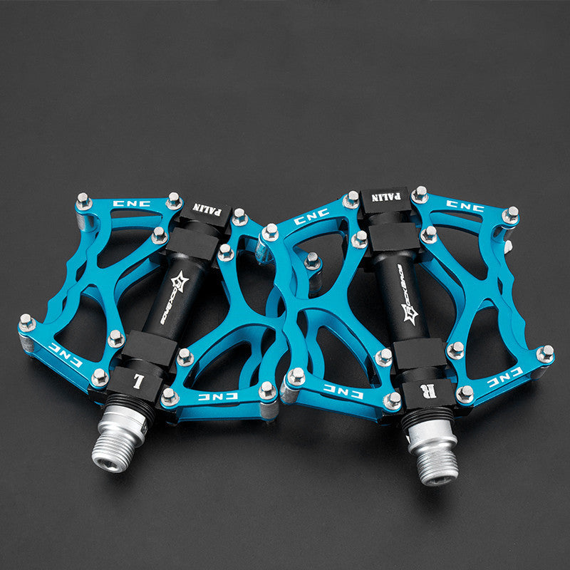 Pair of blue Flat Aluminium Bicycle Pedals with black axles on a dark background