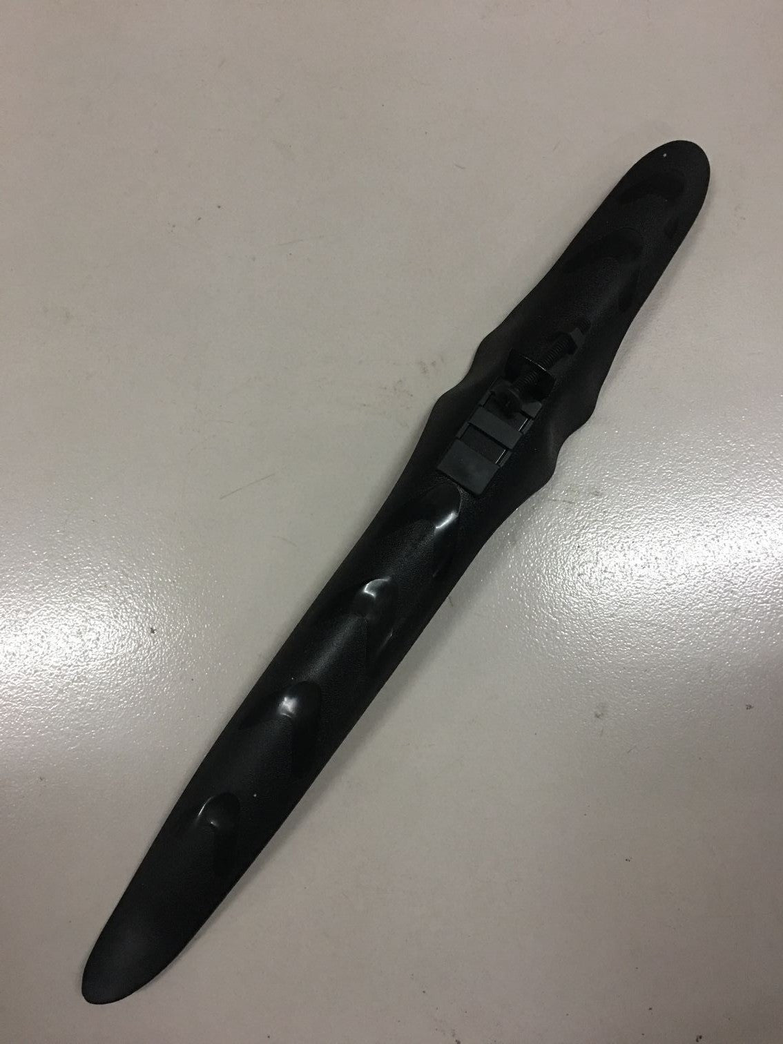 Black plastic bike mudguard on a white surface