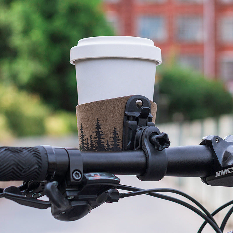 Bicycle handlebar with a cup holder and a white coffee cup on a blurred background