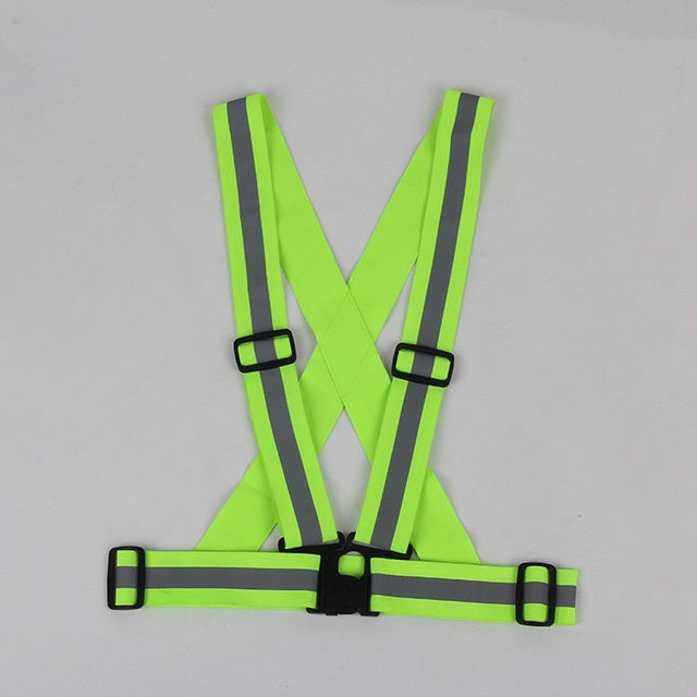 Green safety vest with reflective stripes on a gray background