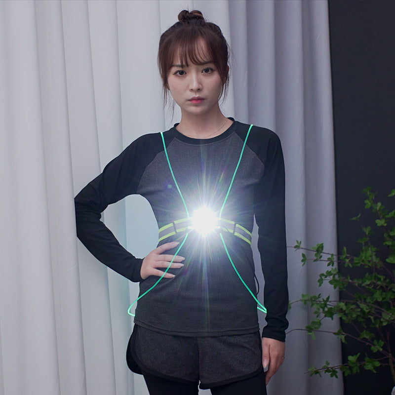 Person wearing a black outfit with hi-viz reflective vest with integrated LED light in front of white curtains