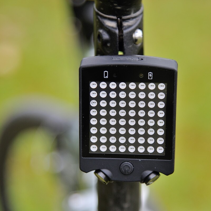 Bicycle light with LED display on a blurred green background