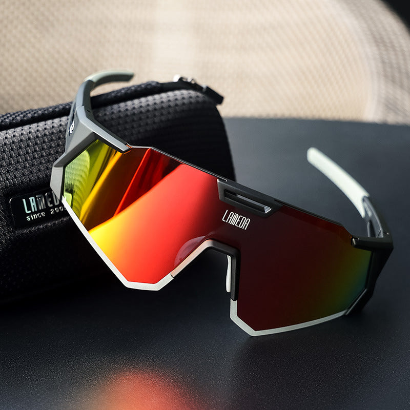 Polarized cycling sunglasses with red reflective lenses on a black surface