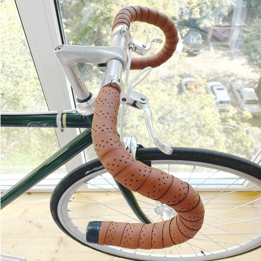 Bicycle with brown handlebar tape indoors