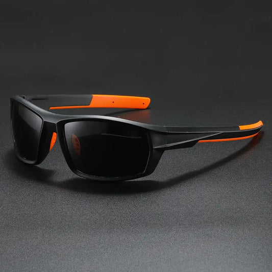 Black and orange polarized cycling sunglasses on a dark gray background