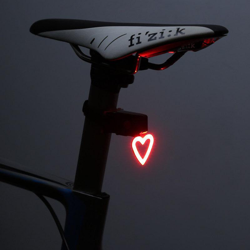 Bicycle seat with a red heart-shaped light on a dark background