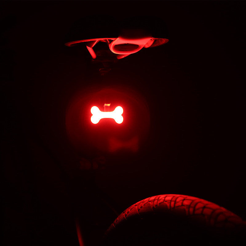 Rechargeable USB Bicycle Rear Light shaped like a bone on a dark background