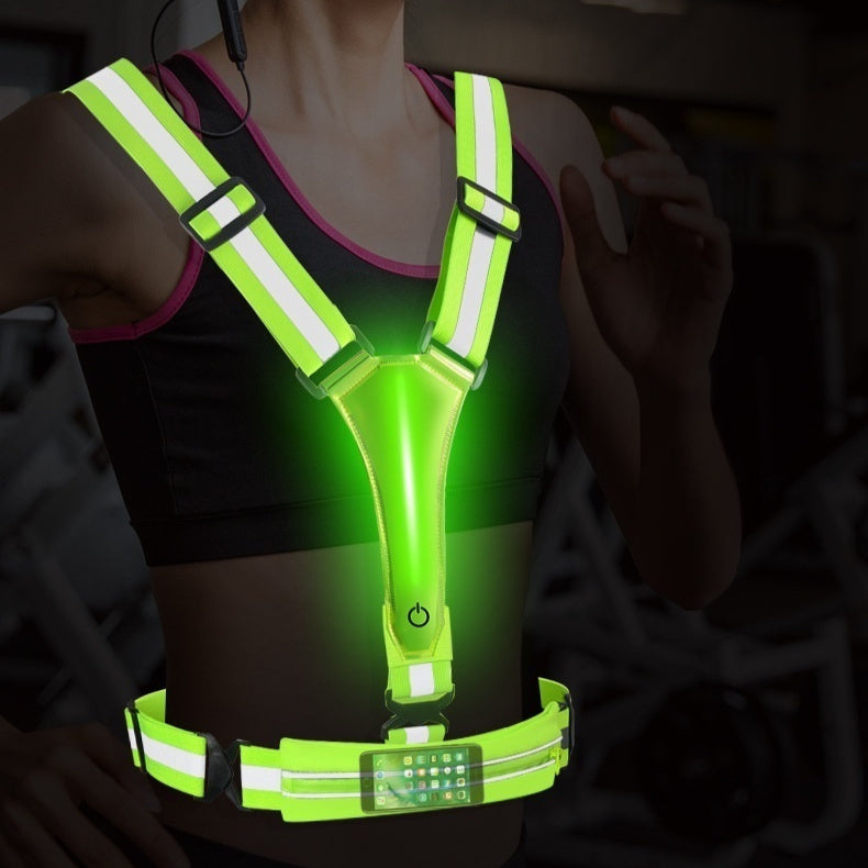 Person wearing a green reflective safety vest with LED lights in a dark setting