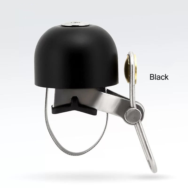 Black bicycle bell with silver clapper on a light gray background