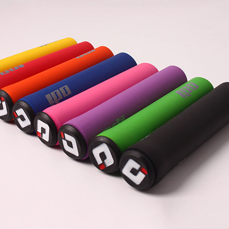 Colorful silicone bicycle handlebar grips arranged in a row on a light gray background