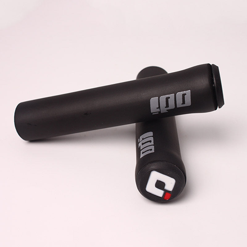 Black bicycle handlebar grips with visible branding on a light gray background