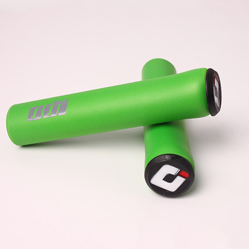 Green silicone bicycle handlebar grips with visible branding on a white background