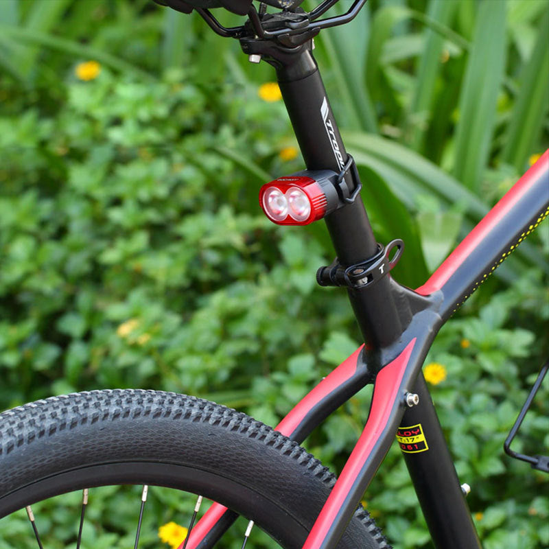 Bicycle with a red light attached to the frame against a green background