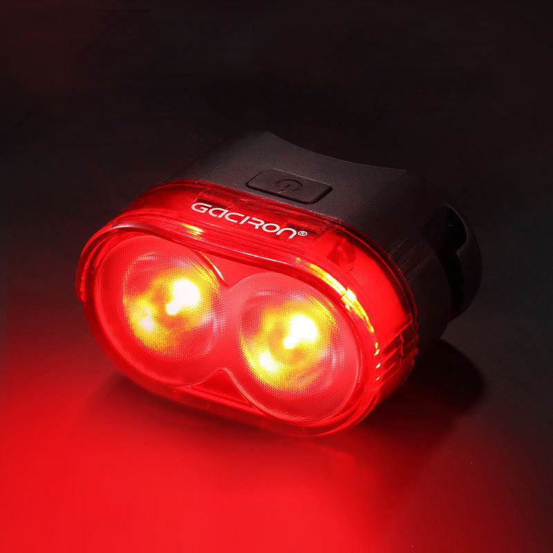 Red bicycle light with two visible bulbs on a black background