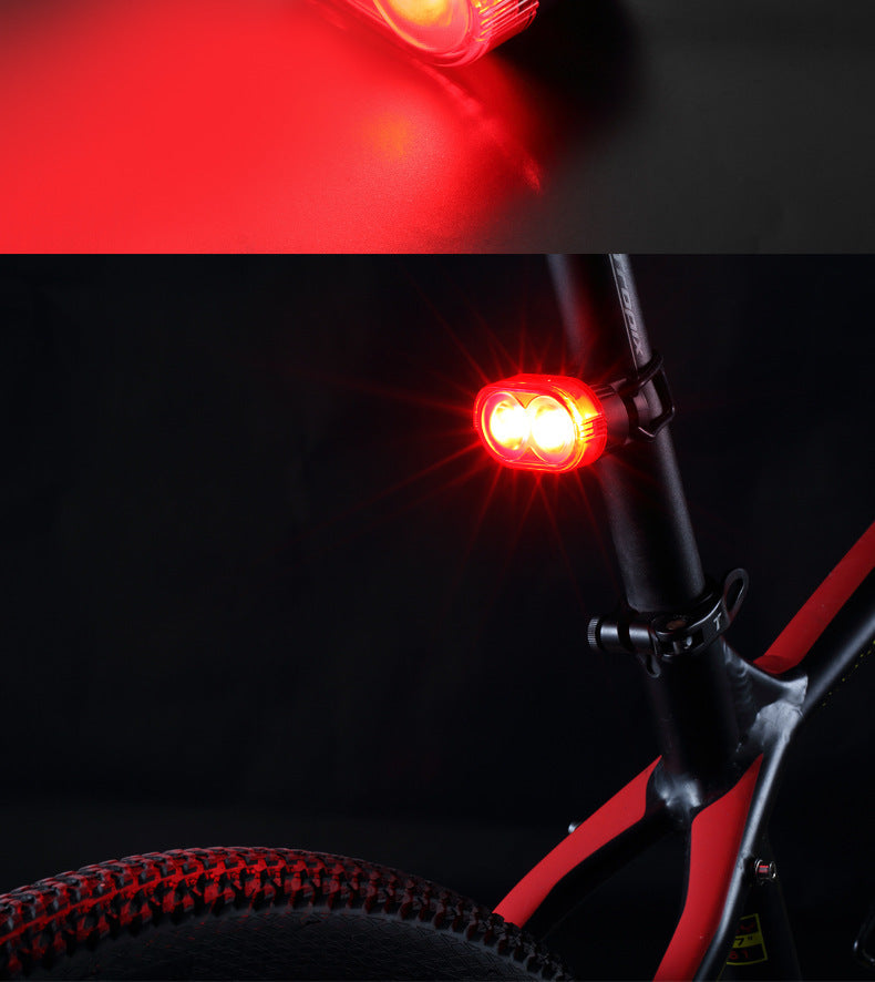 Bicycle light attached to a bike frame with close-up of red light on dark background