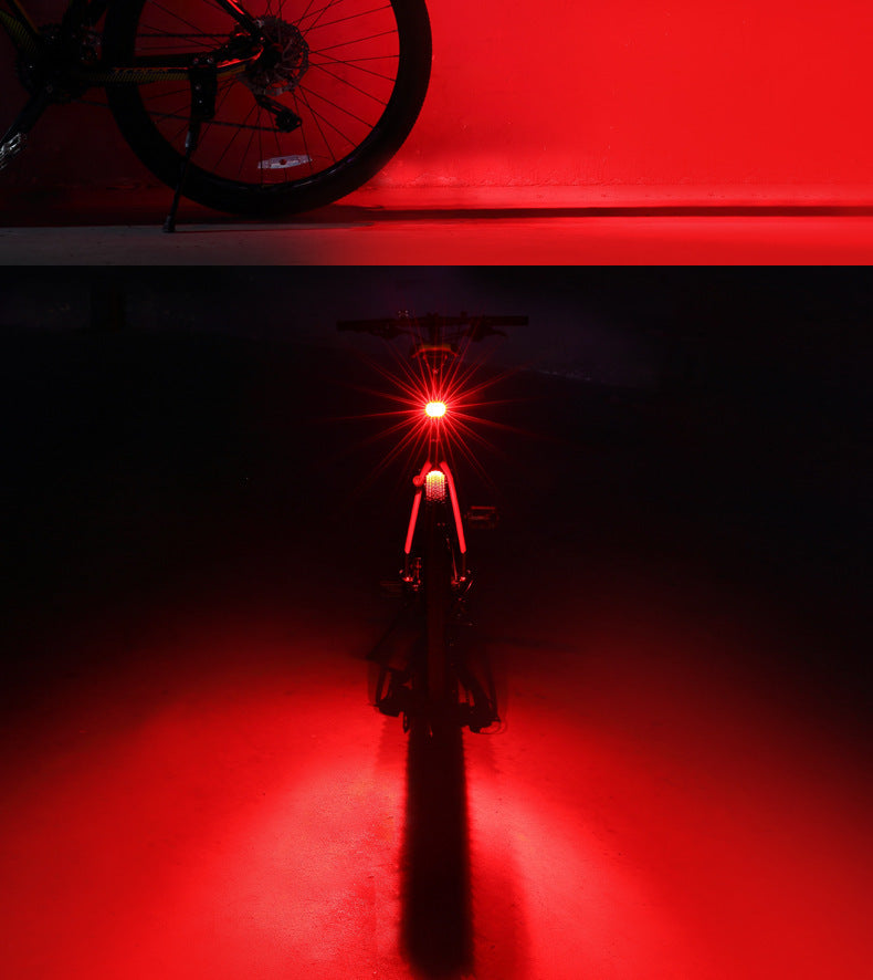 Bicycle with a red rear light on a dark background