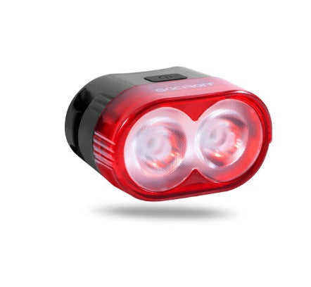 Red bicycle light with two lenses on a white background