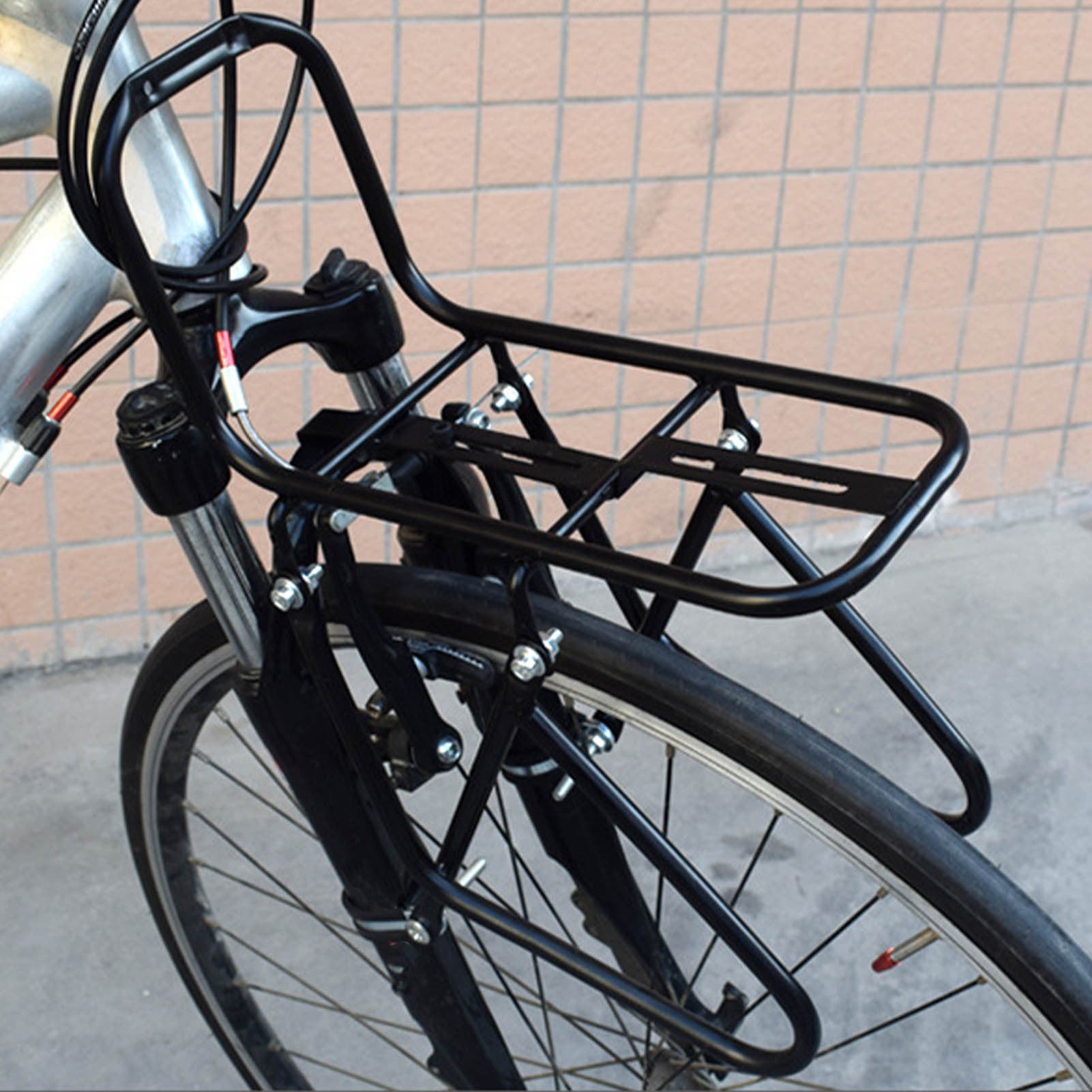 Black bicycle rack attached to a bike with a tiled wall background