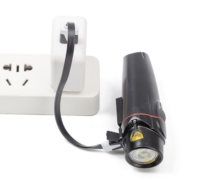 Black USB Rechargeable Front Bicycle Light with USB cable attached to a white wall socket on a white background