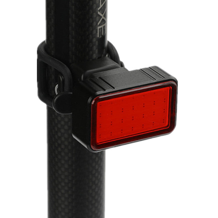 Red LED bicycle light attached to a black seatpost against a white background.