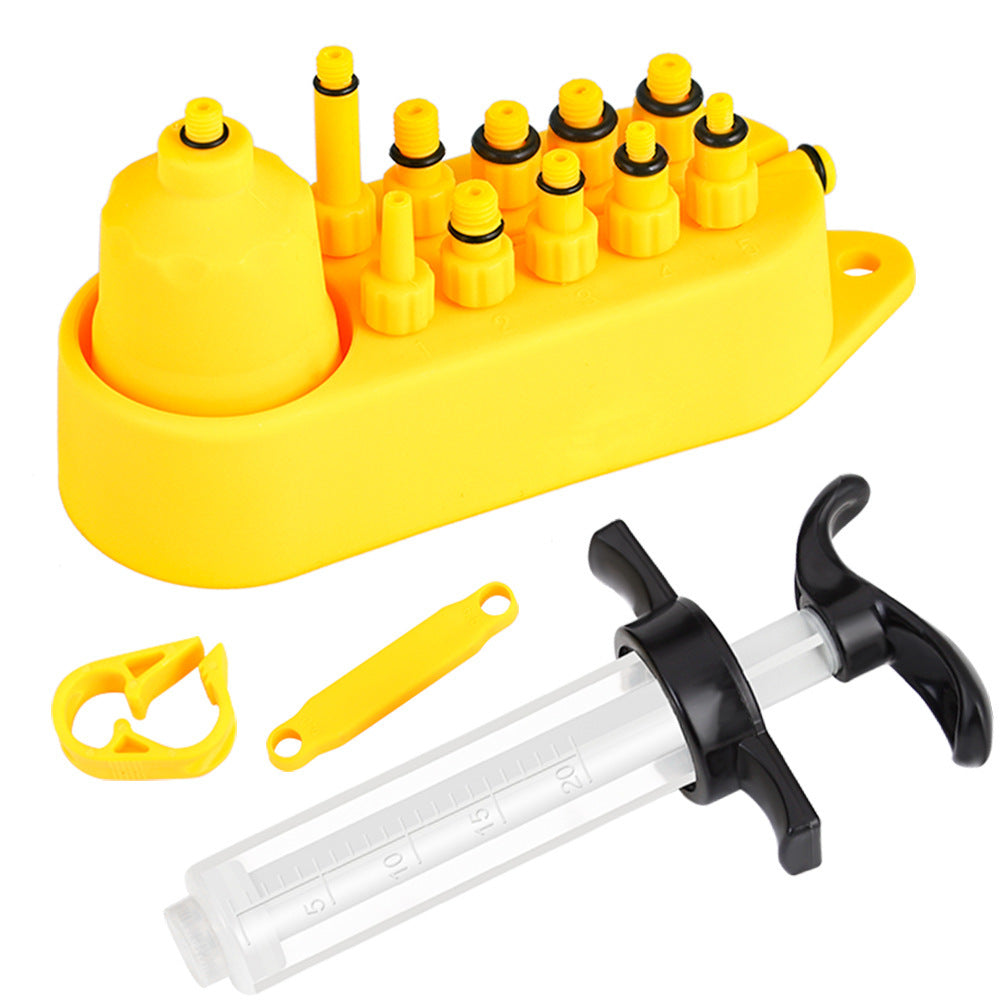 Yellow bicycle disc brake fluid replacement kit with various components on a white background