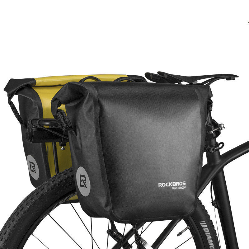 Black bicycle pannier bag with Rockbros branding attached to a bike.
