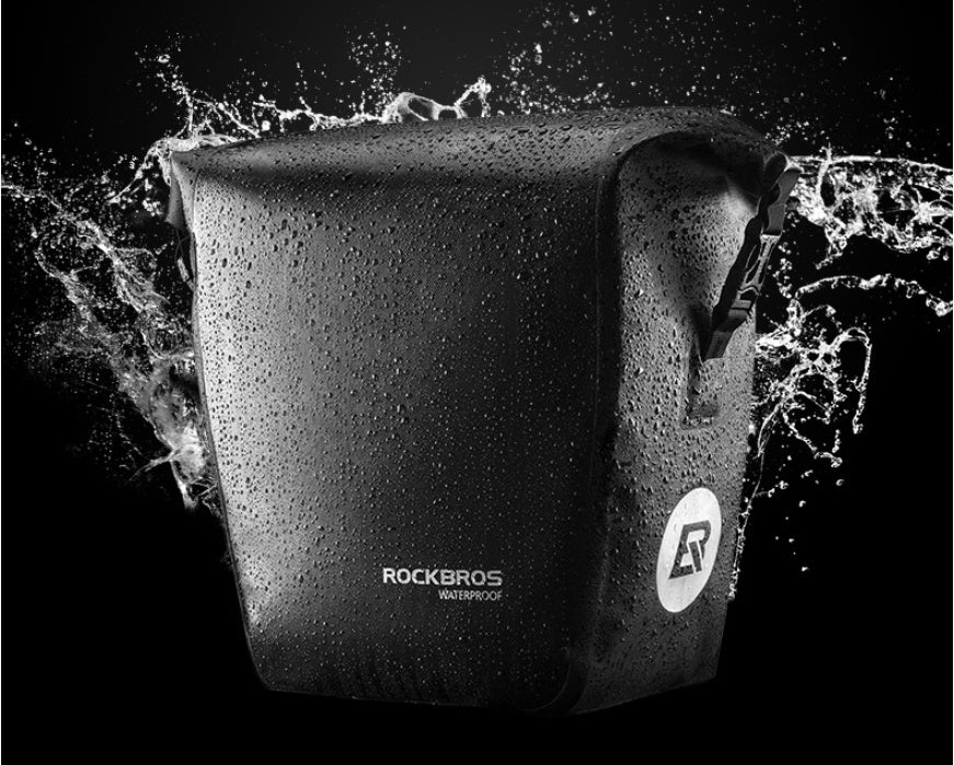 Waterproof Bicycle Bag / Pannier with 'RockBros' branding being splashed by water on a black background