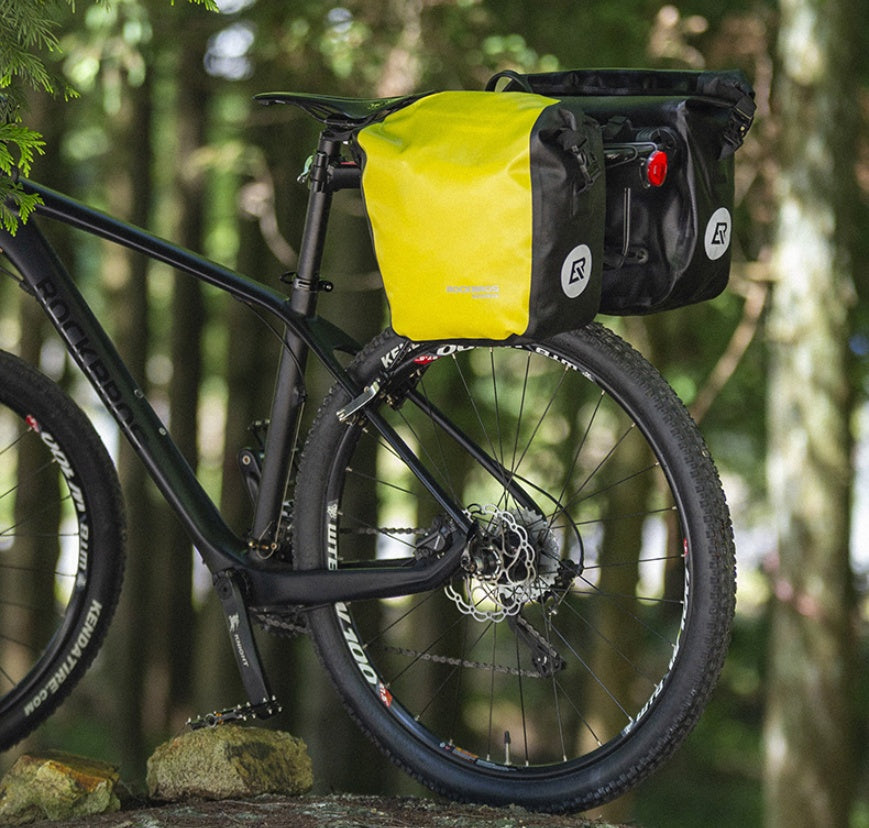 Bicycle with yellow and black bags in a forest setting