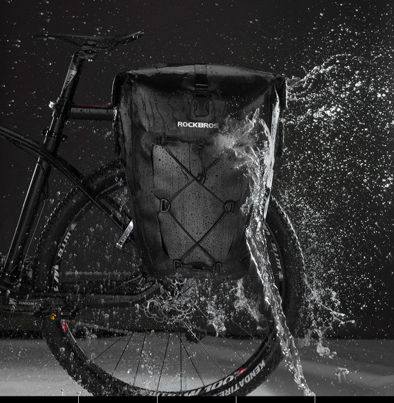 Bicycle with a backpack labeled 'RockBros' splashing through water at night.