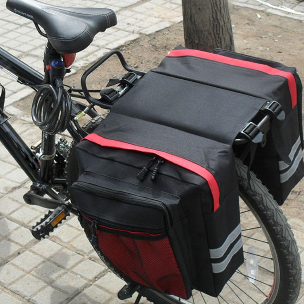 Black and red rear bicycle pannier attached to a bike on a sidewalk.