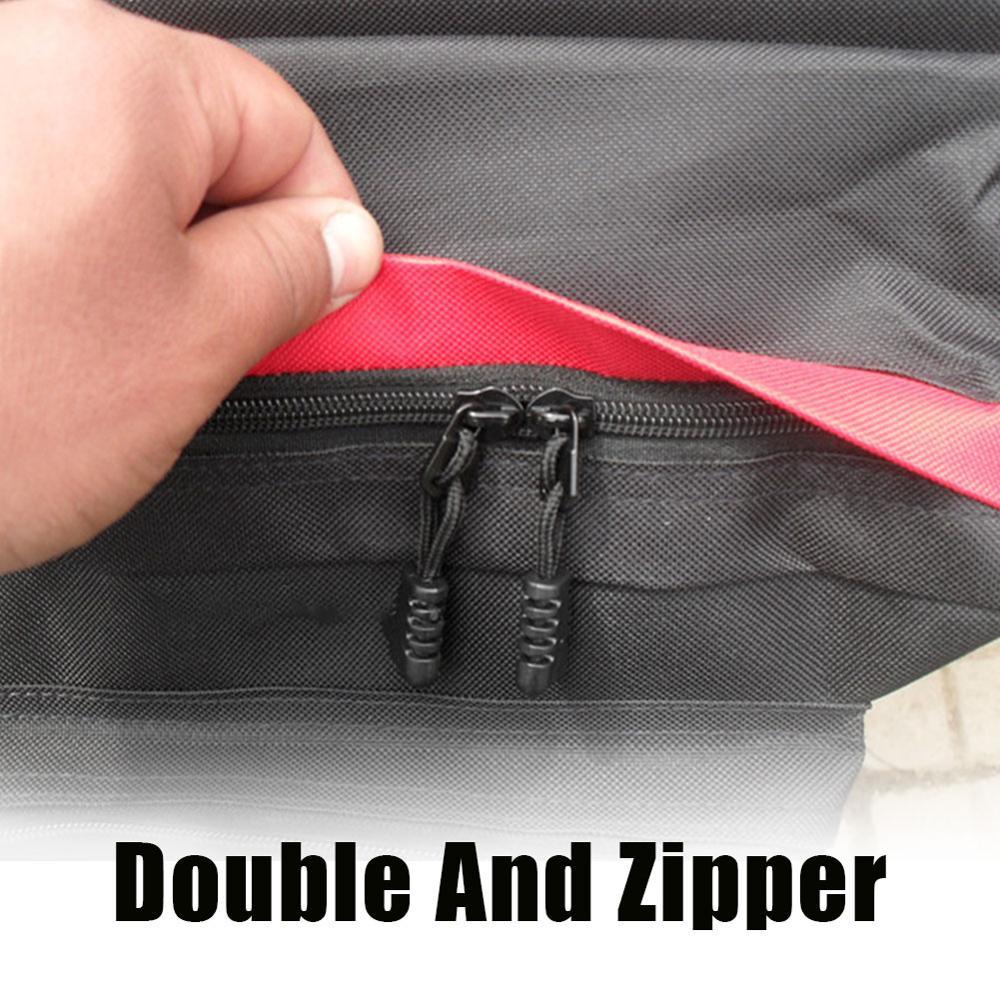 Close-up of a black and red rear bicycle pannier with double zippers, held by a hand.